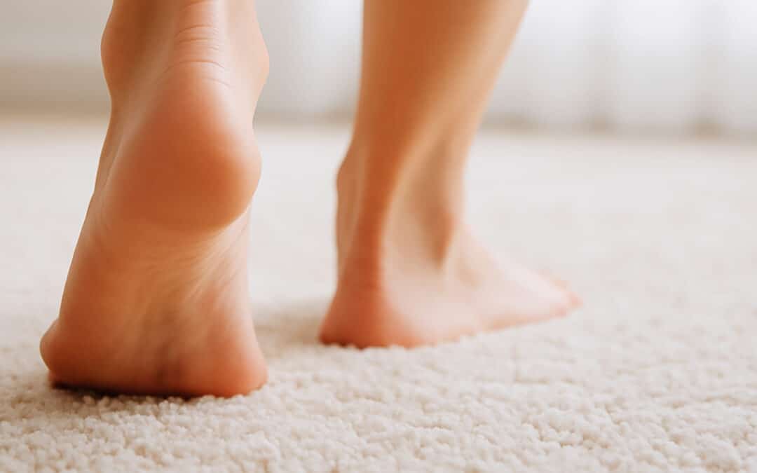 Bare feet walking on a soft, clean carpet in a bright room, showing the comfort that comes from regularly cleaning carpets.
